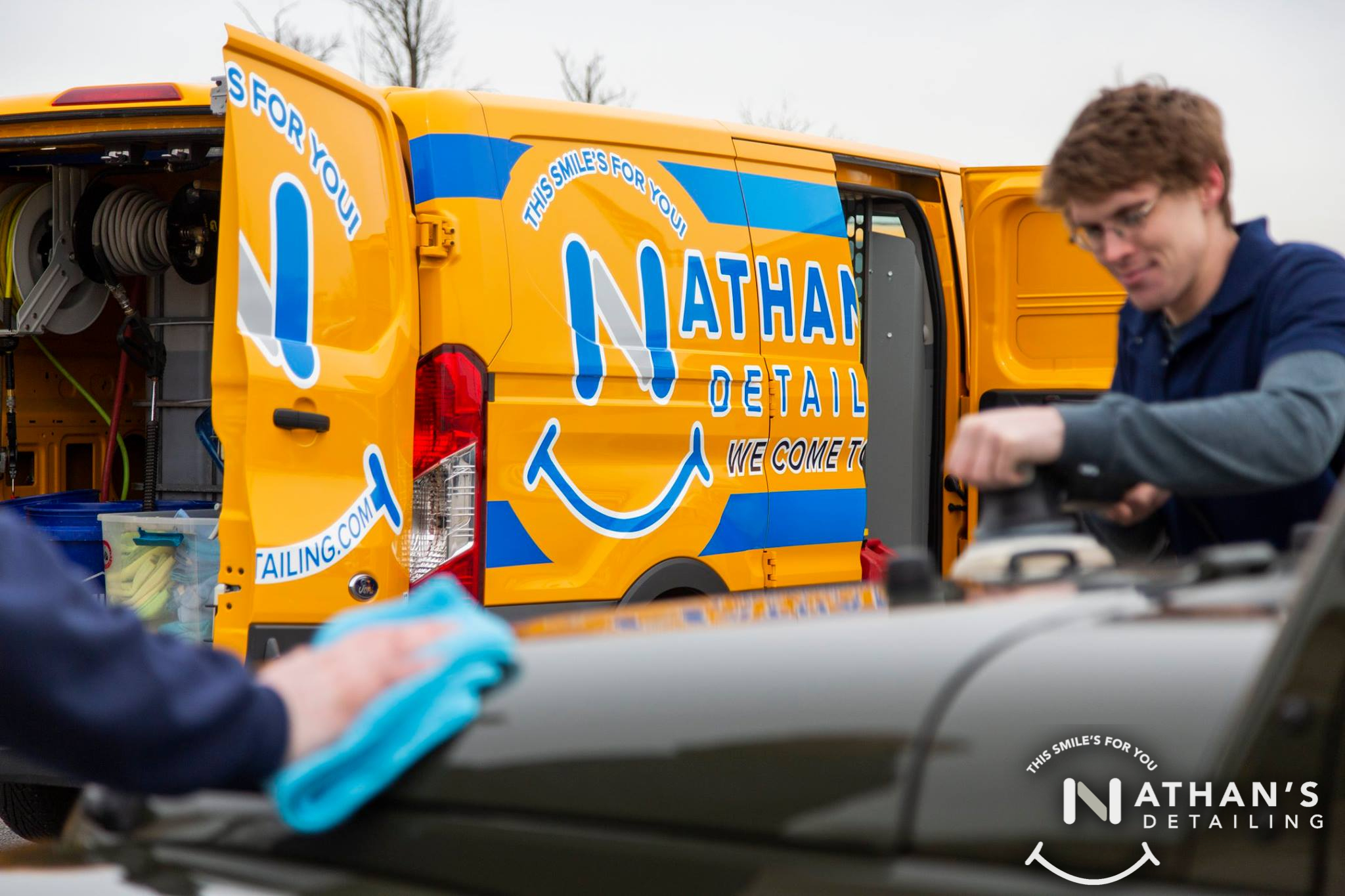 Technician polishing vehicle next to detail van during mobile detailing in Pepper Pike