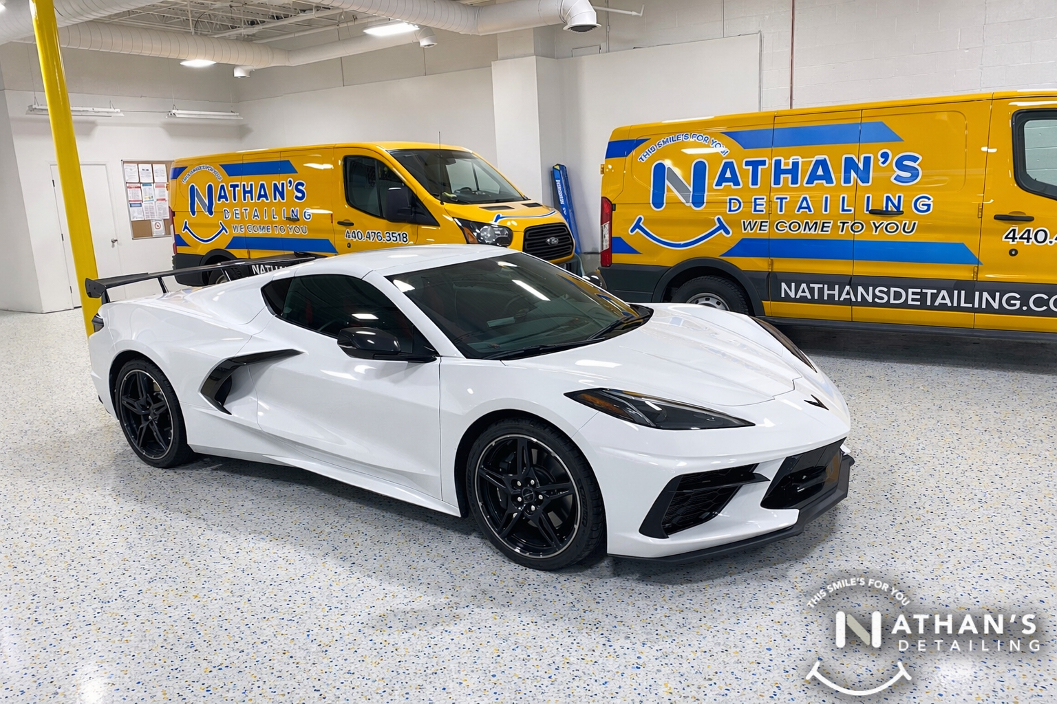 corvette c8 with dark window tint and nathans detailing vans in the background