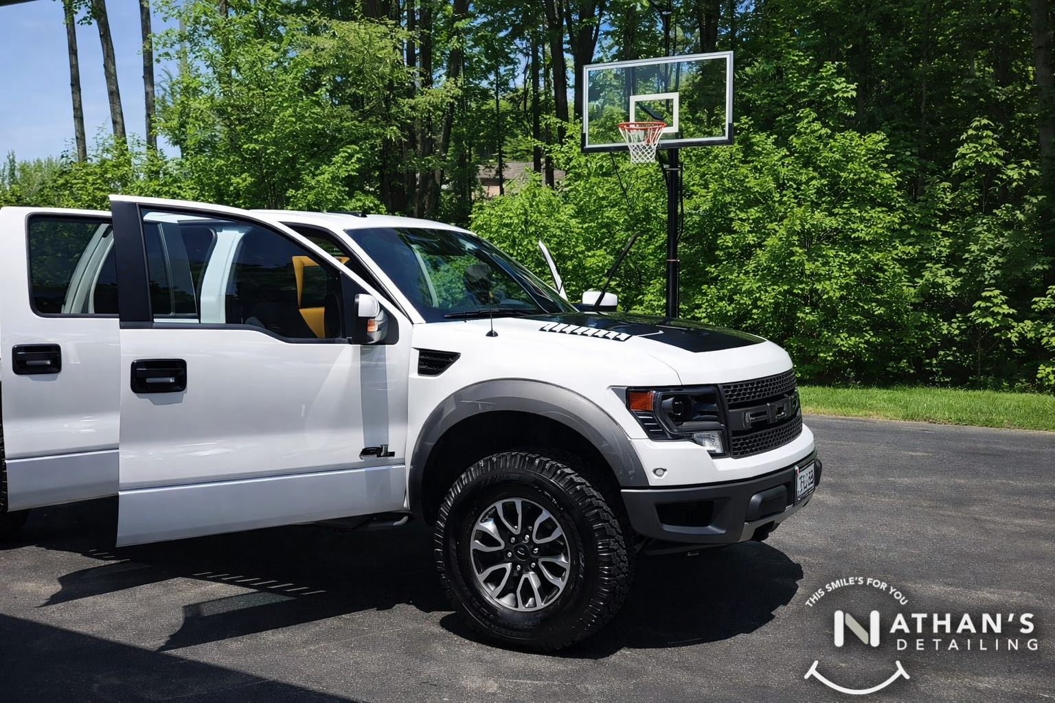White raptor truck detailed with doors open during mobile detailing