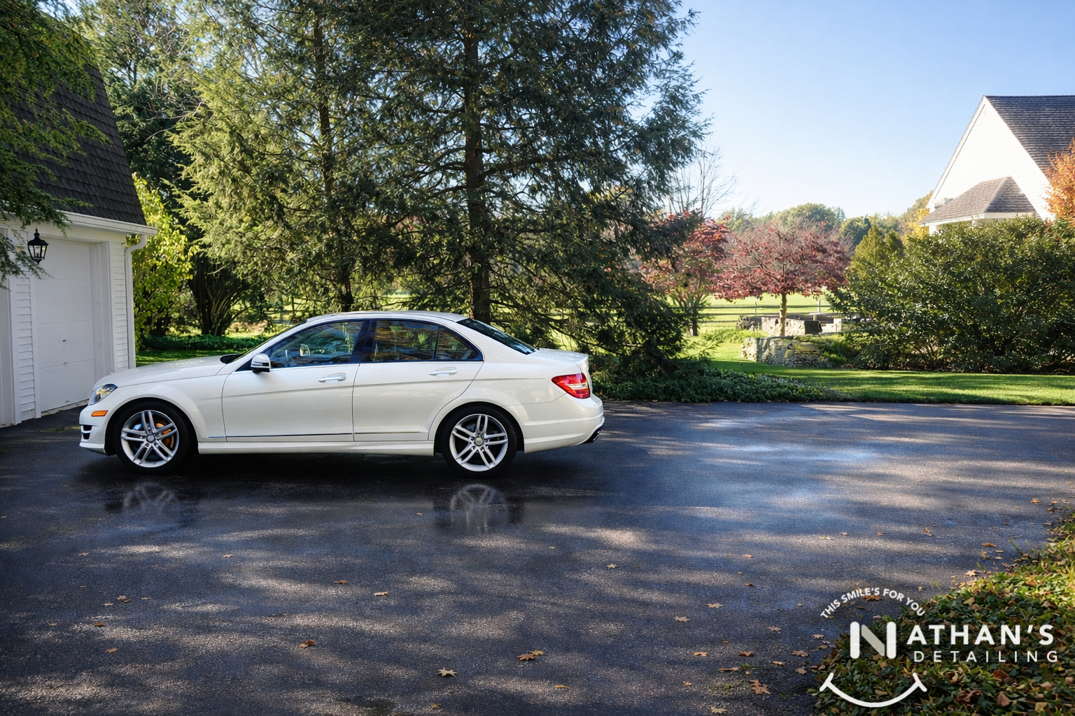 White sedan detailed side view on driveway during mobile detailing