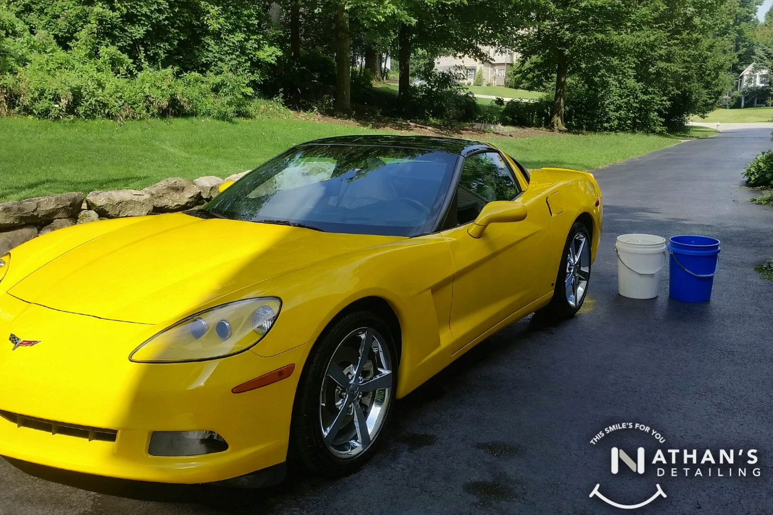 Yellow corvette wash buckets driveway during mobile detailing