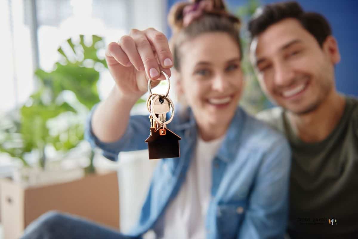 Happy couple dangling keys after buying their new home