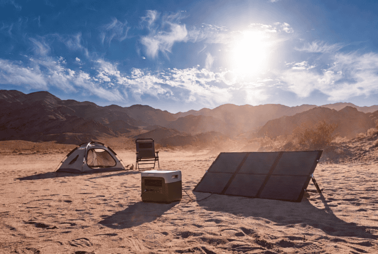 Best portable solar generator with foldable solar panels set up at a Nevada desert campsite under bright sun, with tent and mountains in background.