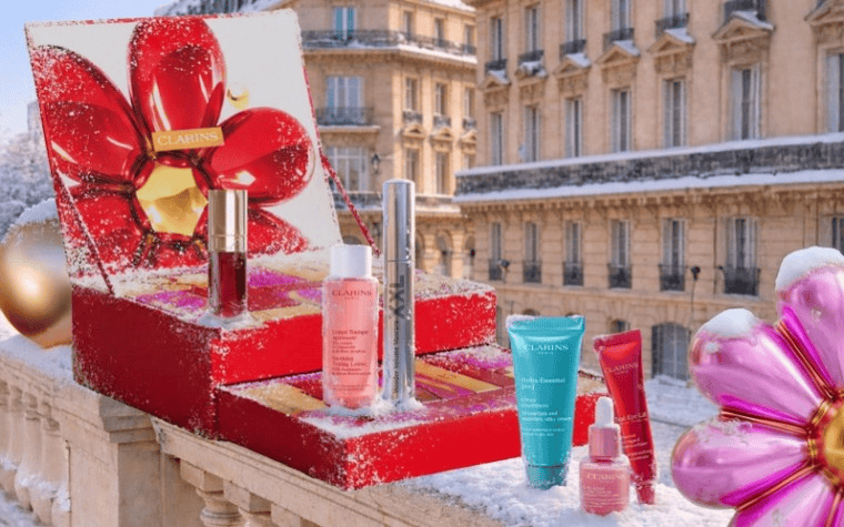 Clarins advent calendar 2026 open on a snowy Paris balcony, red flower lid with skincare and makeup minis