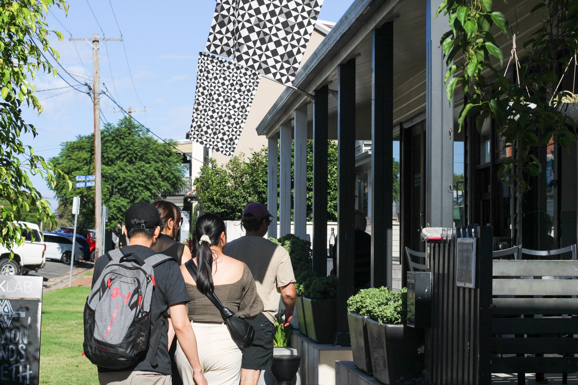 Group of tourists exploring a city street during a country town tour, enjoying local sights and architecture.