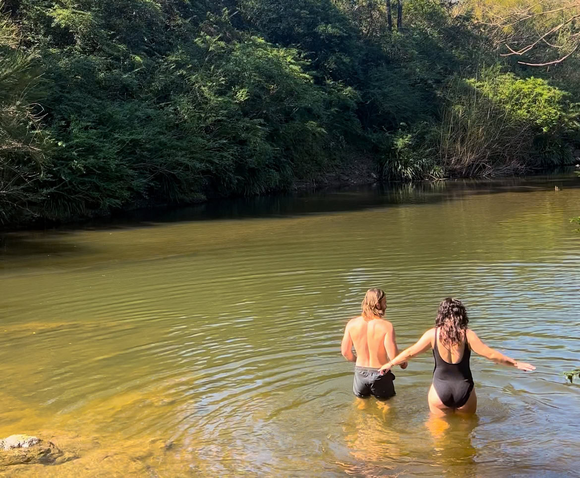 Scenic river view with two women enjoying a peaceful moment in the water during a country town river and farm tour.