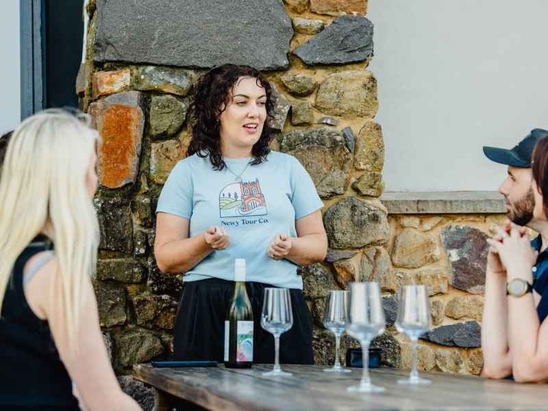 Guided tour host explaining local attractions to group at Newy Tour Co. event in Newcastle, Australia, providing expert tourism experiences.