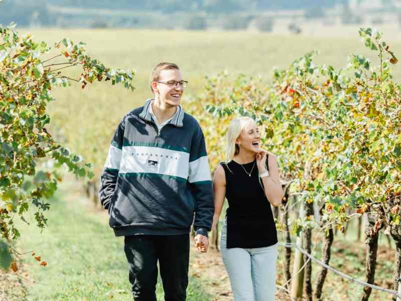 Vineyard tour with a couple enjoying wine tasting and exploring lush grapevines on a sunny day in New South Wales. Perfect for wine enthusiasts and tourists seeking local wine experiences.