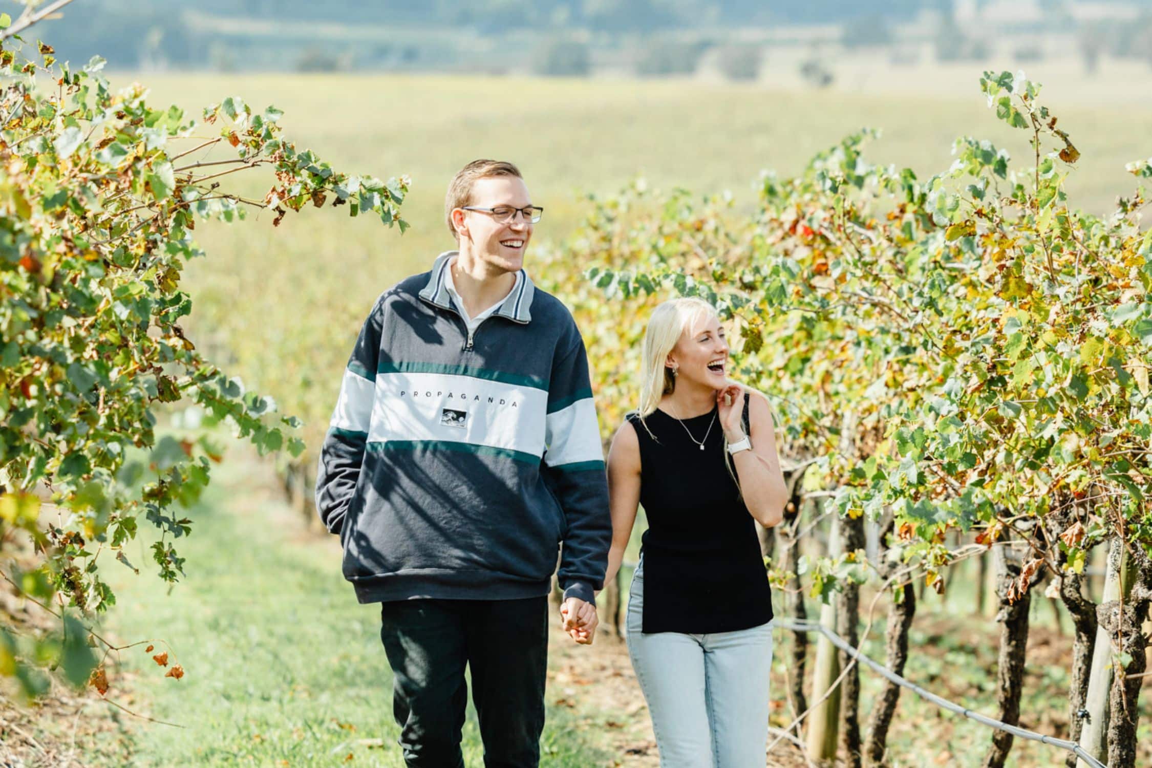 Vineyard tour with a couple enjoying wine tasting and exploring lush grapevines on a sunny day in New South Wales. Perfect for wine enthusiasts and tourists seeking local wine experiences.