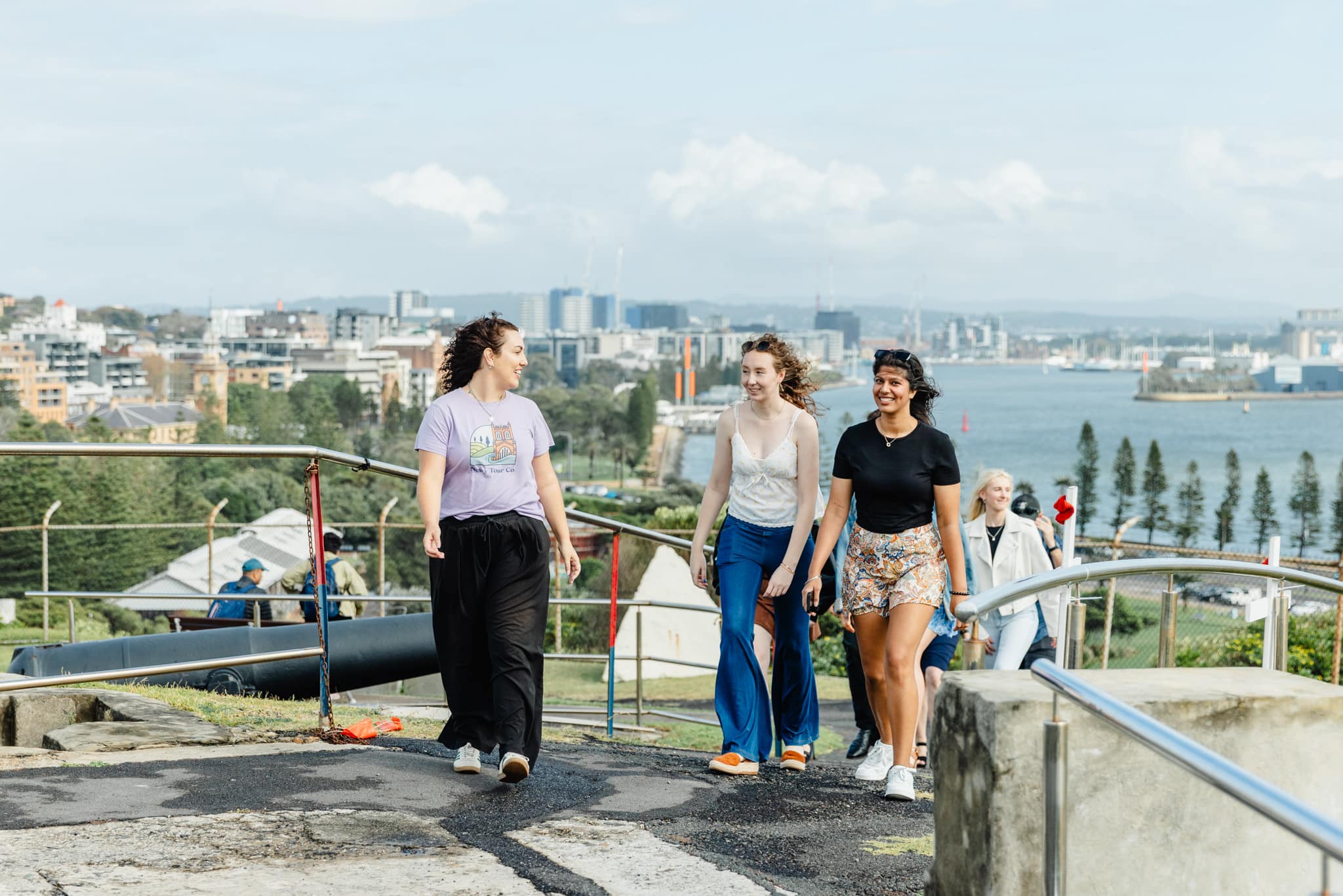Enjoying a guided tour with friends at Newcastle scenic lookout with views of the harbor and city skyline in the background. Perfect for group adventures and sightseeing tours.
