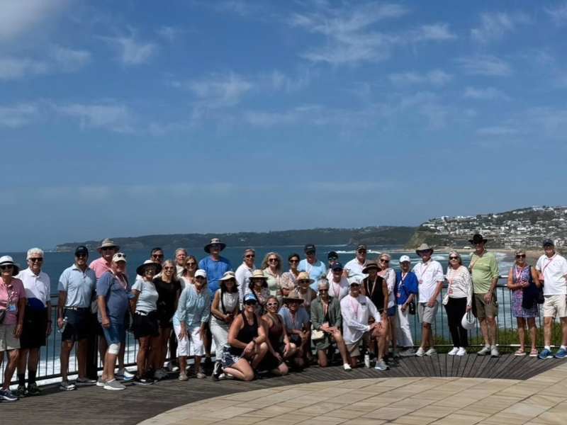 Group tour of tourists on a scenic coastal lookout in Newcastle, Australia, enjoying guided sightseeing travel, beach views, and luxury coach transportation with Newy Tour Co.
