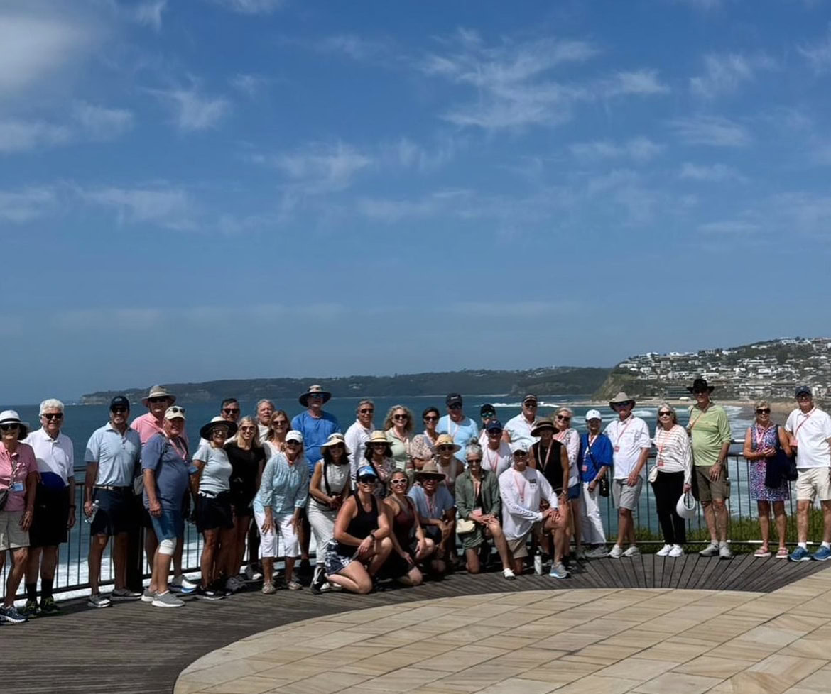 Group tour of tourists on a scenic coastal lookout in Newcastle, Australia, enjoying guided sightseeing travel, beach views, and luxury coach transportation with Newy Tour Co.