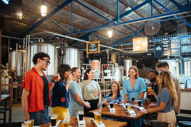 Group enjoying craft beer tasting at a Newcastle brewery, showcasing local brewing culture and vibrant atmosphere.