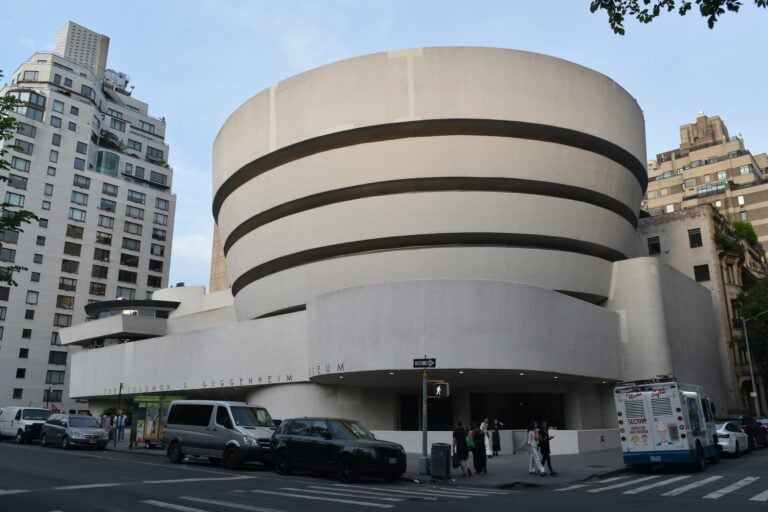 Street view of the Guggenheim Museum in New York, one of the iconic museums in New York, featuring its unique spiral architecture and city backdrop.