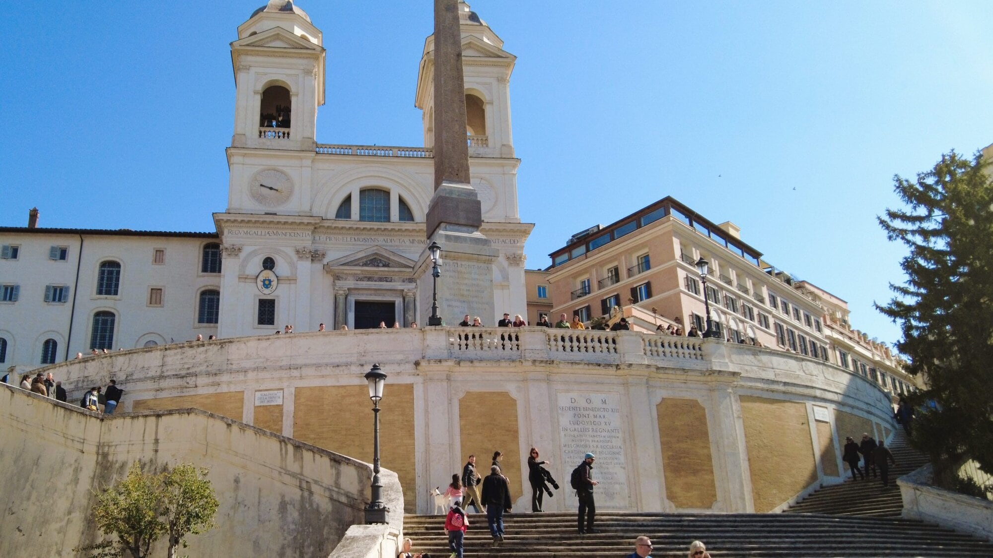 The Spanish Steps, a must-see attraction in Rome, bustle with people against the backdrop of the Trinità dei Monti church.