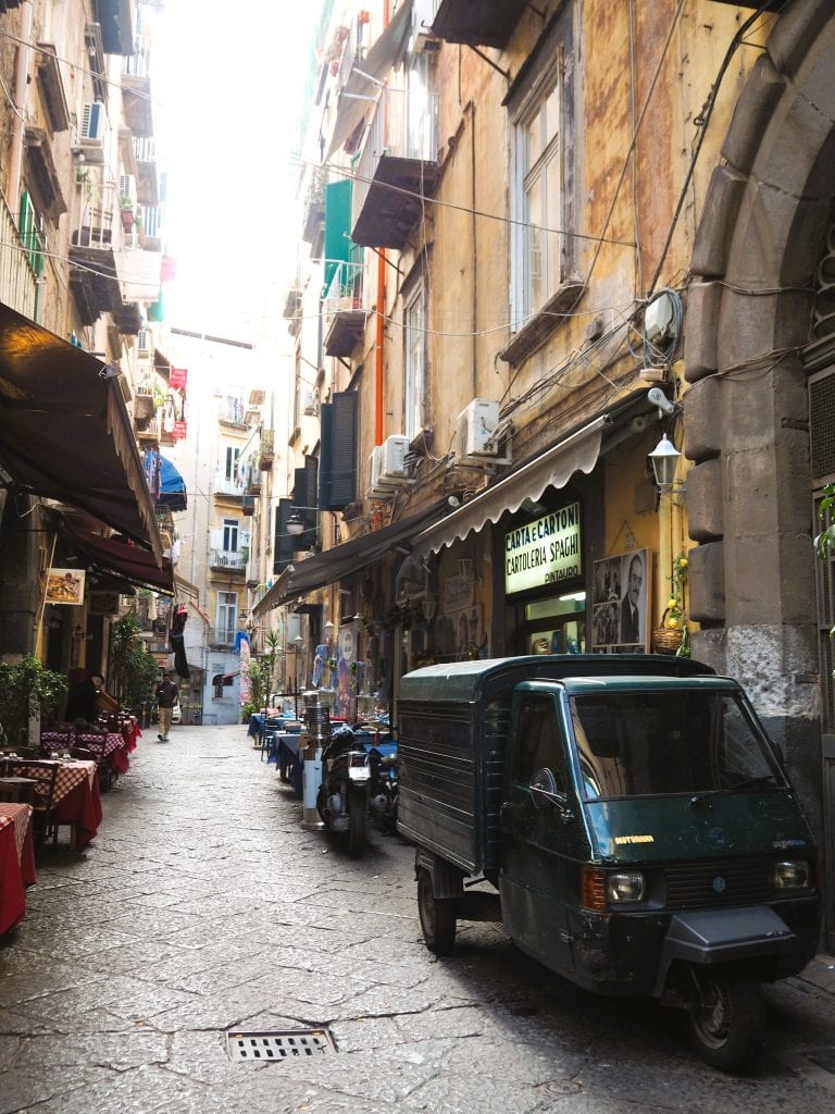 A small truck parked in a narrow alleyway hints at the authentic charm you’ll find while exploring Naples attractions and discovering things to do in Naples.