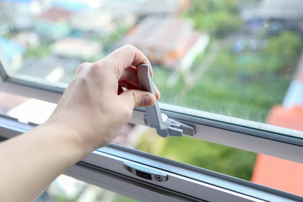 Opening the window to let in the fresh air and city views.