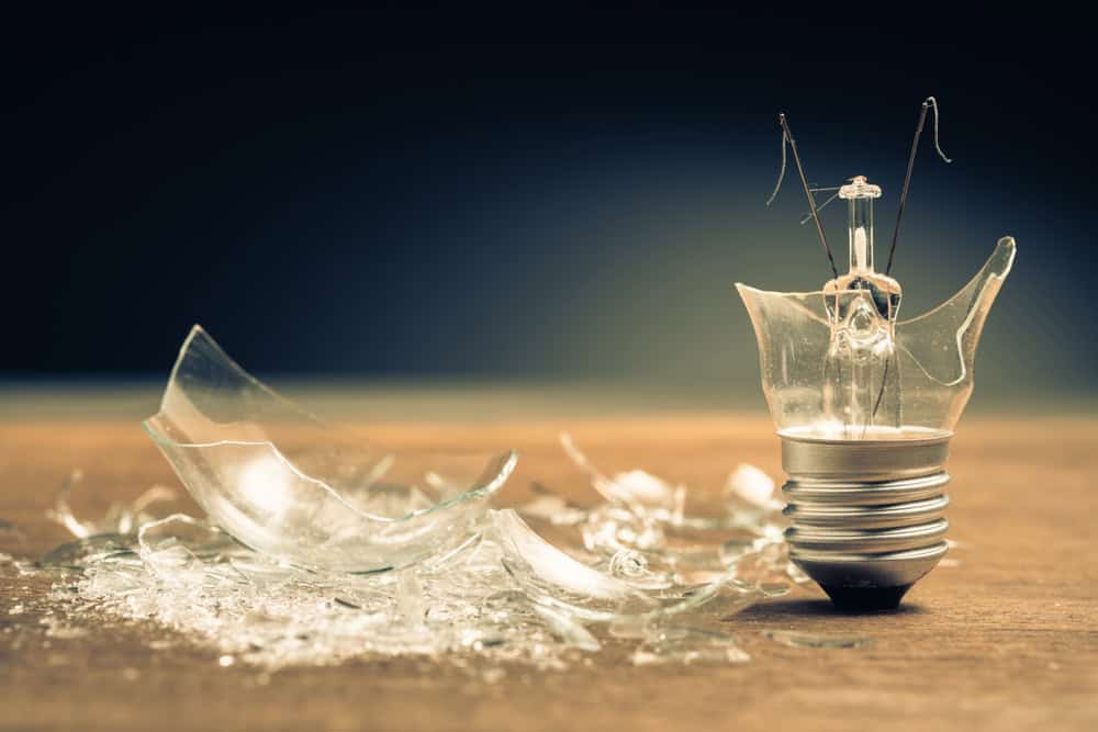 A broken lightbulb lies in pieces.