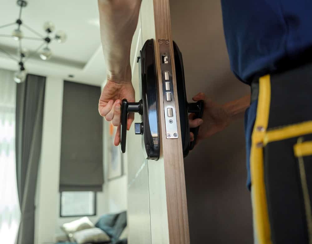 Locksmith installing a new digital door lock.