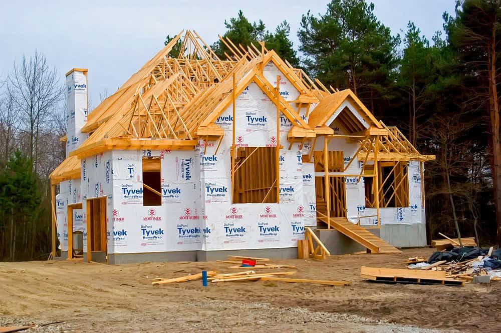 A new home under construction, surrounded by the tranquility of a forested backdrop.