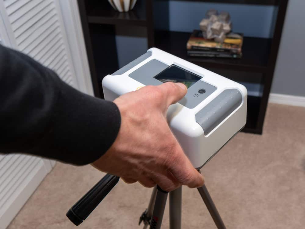 Adjusting a high-tech radon monitor for precise indoor readings.