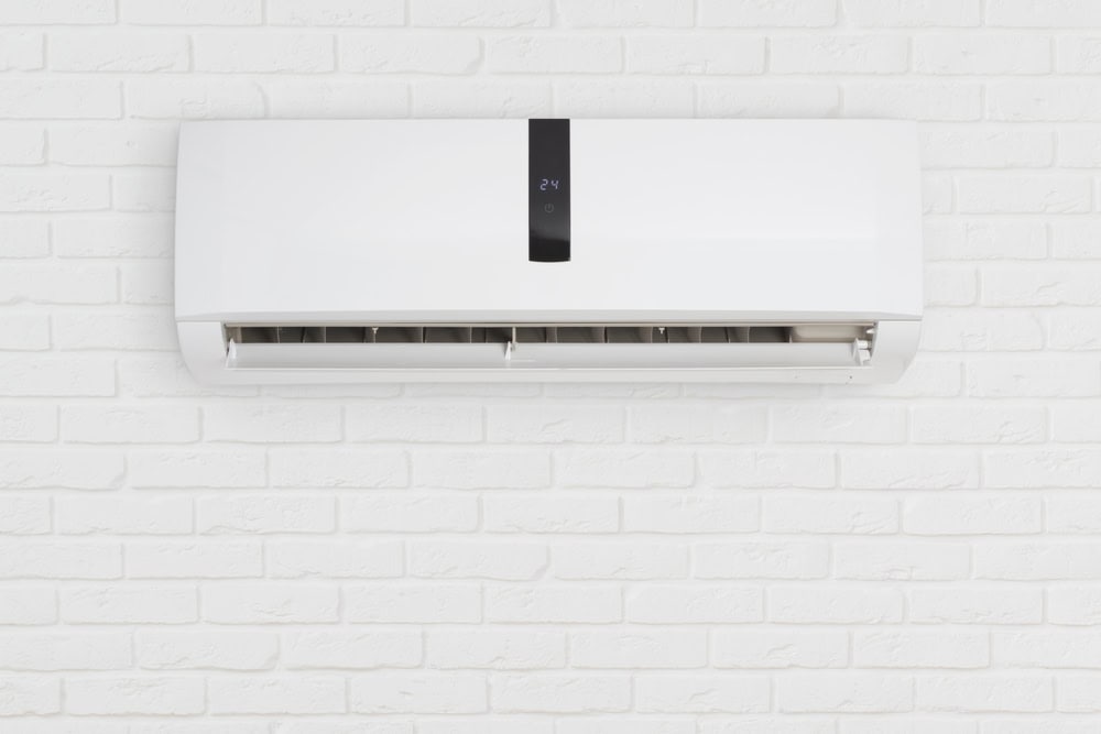 Stay cool with this sleek, modern air conditioner mounted on a pristine white brick wall.