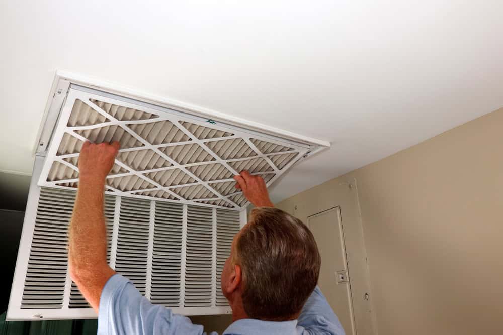Changing the air filter in a home HVAC system for better air quality.