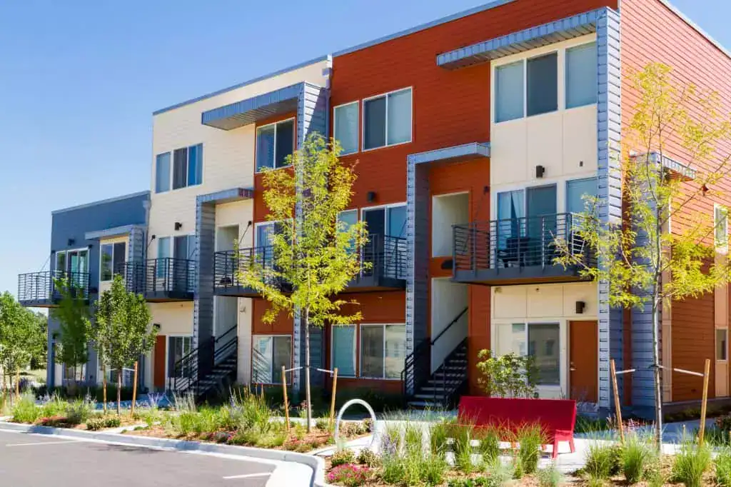 Modern townhomes with vibrant facades, lush landscaping, and inviting balconies—suburban living at its finest!