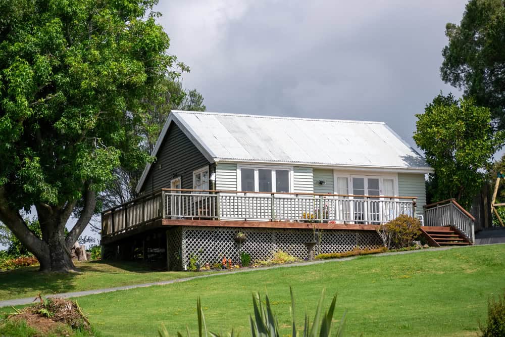 Cozy cottage nestled among lush greenery, with a welcoming porch and vibrant garden.