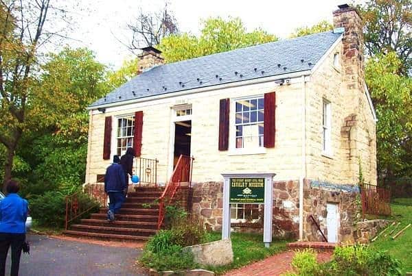 Historic Lockhouse along the C&O Canal towpath, featuring original stone construction, red shutters, and brick steps welcoming visitors to explore canal history.