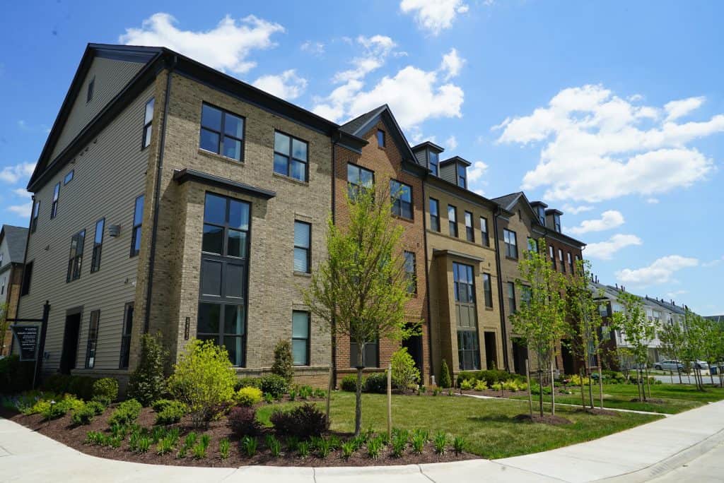 Modern townhomes basking in the sunshine, showcasing sleek architecture and lush greenery.