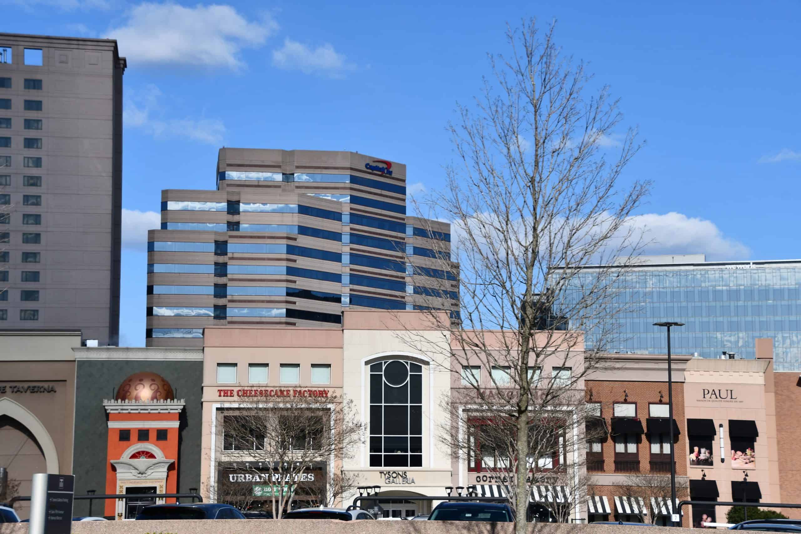 Urban skyline meets street-level charm: A bustling commercial district showcases modern office towers alongside popular eateries like The Cheesecake Factory and Paul, blending big city amenities with neighborhood appeal.
