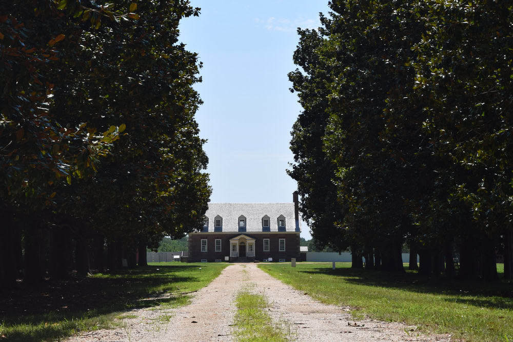Historic elegance: A stately colonial mansion stands at the end of a tree-lined path, inviting visitors to step back in time.