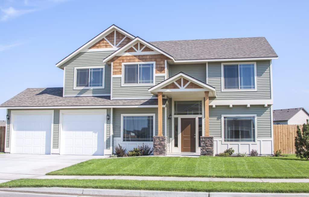 Charming modern suburban home with a neatly manicured lawn and double garage.
