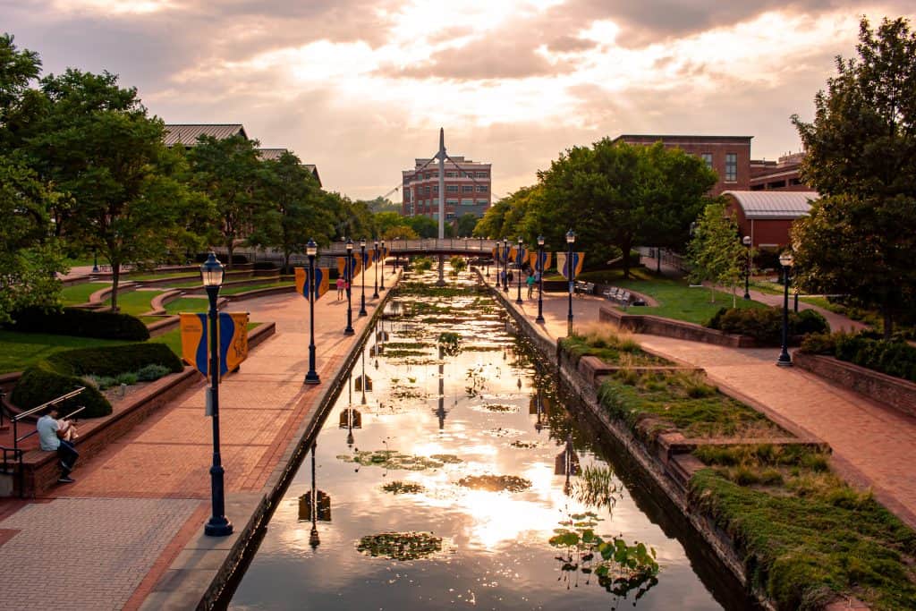 Frederick County Historic Downtown Frederick - Sunset over Frederick's charming Carroll Creek, reflecting golden hues amid a serene urban landscape.