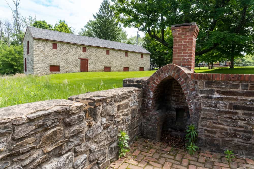 Stone barn and brick oven at historic site.