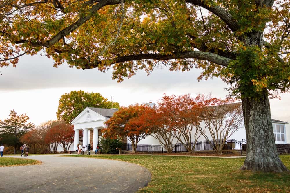 Fall colors frame a white building with pillars and a path leading to the entrance. Manassas Park VA