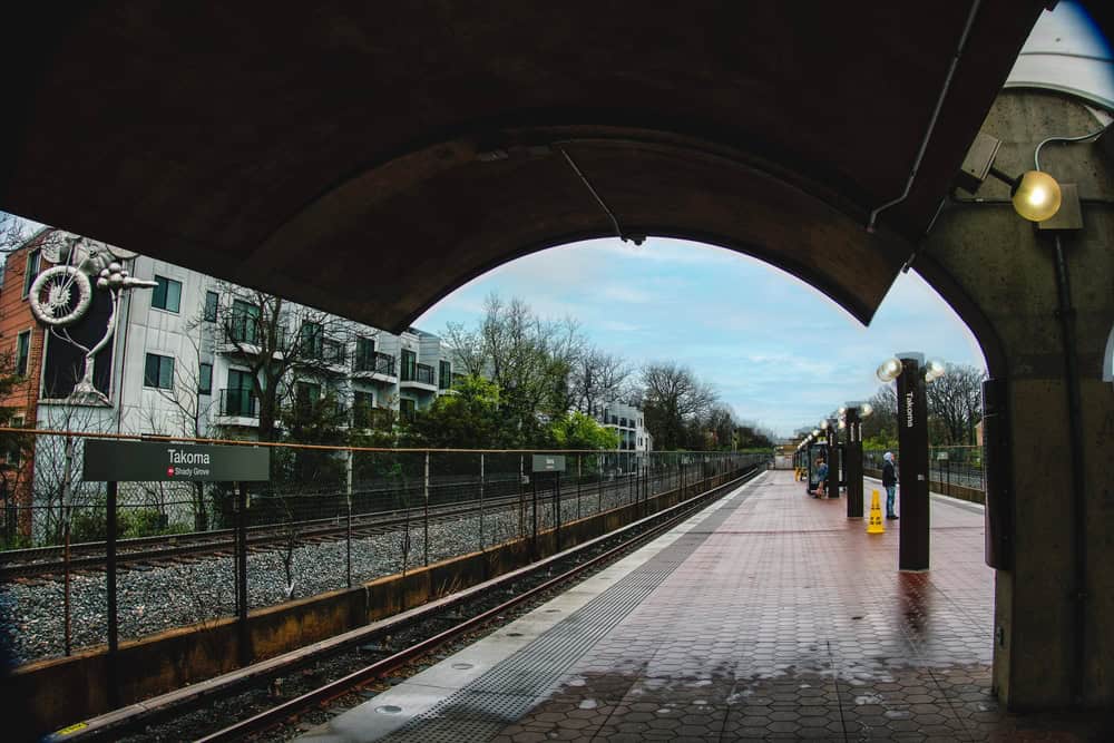 A quiet moment at the train station, with tracks leading into the distance and a serene sky above.