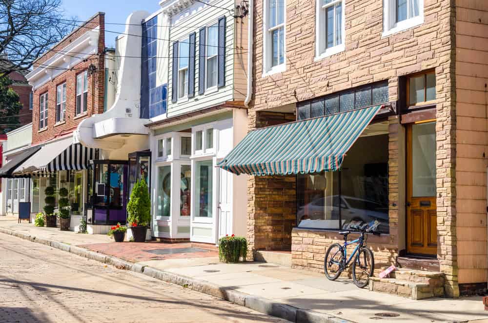 Charming brick storefronts on a sunny day, a bicycle leaning against one.