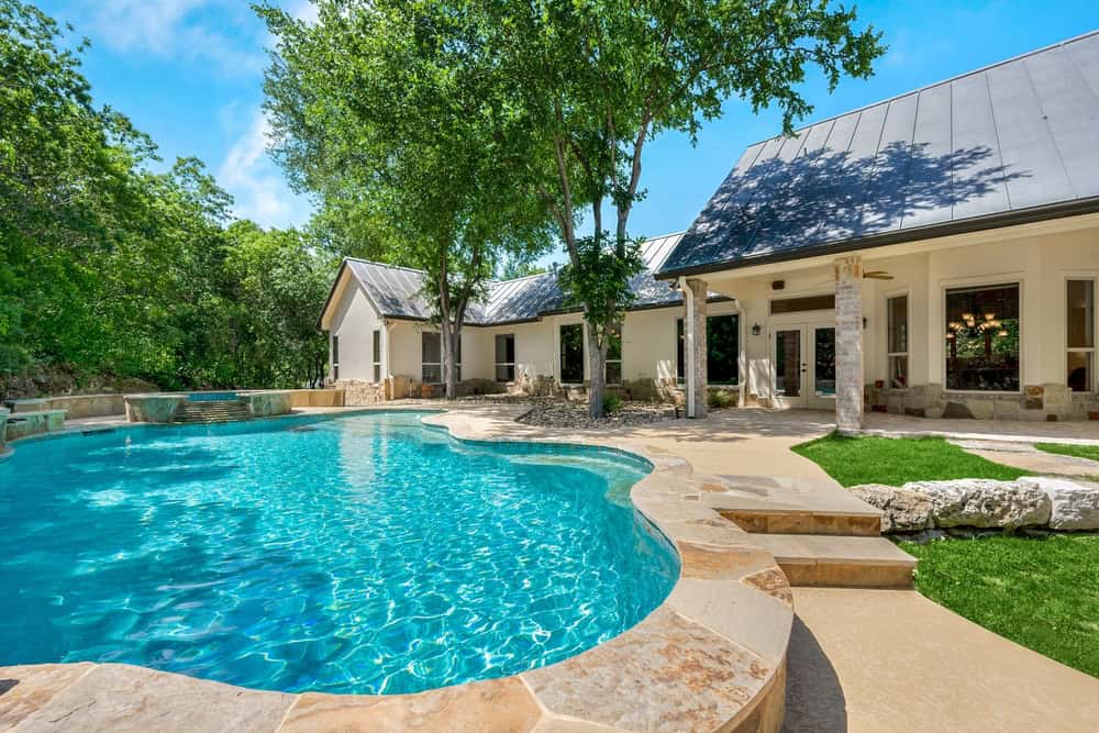 Luxurious traditional home exterior with a swimming pool and elegant architectural details, thoroughly inspected for quality and safety by Next Day Inspect home inspectors.