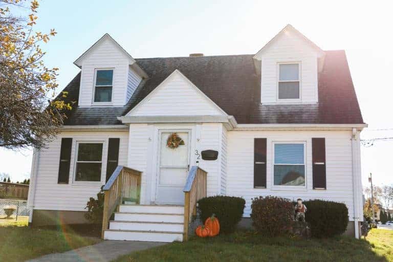 A white Cape Cod style house with dormer windows