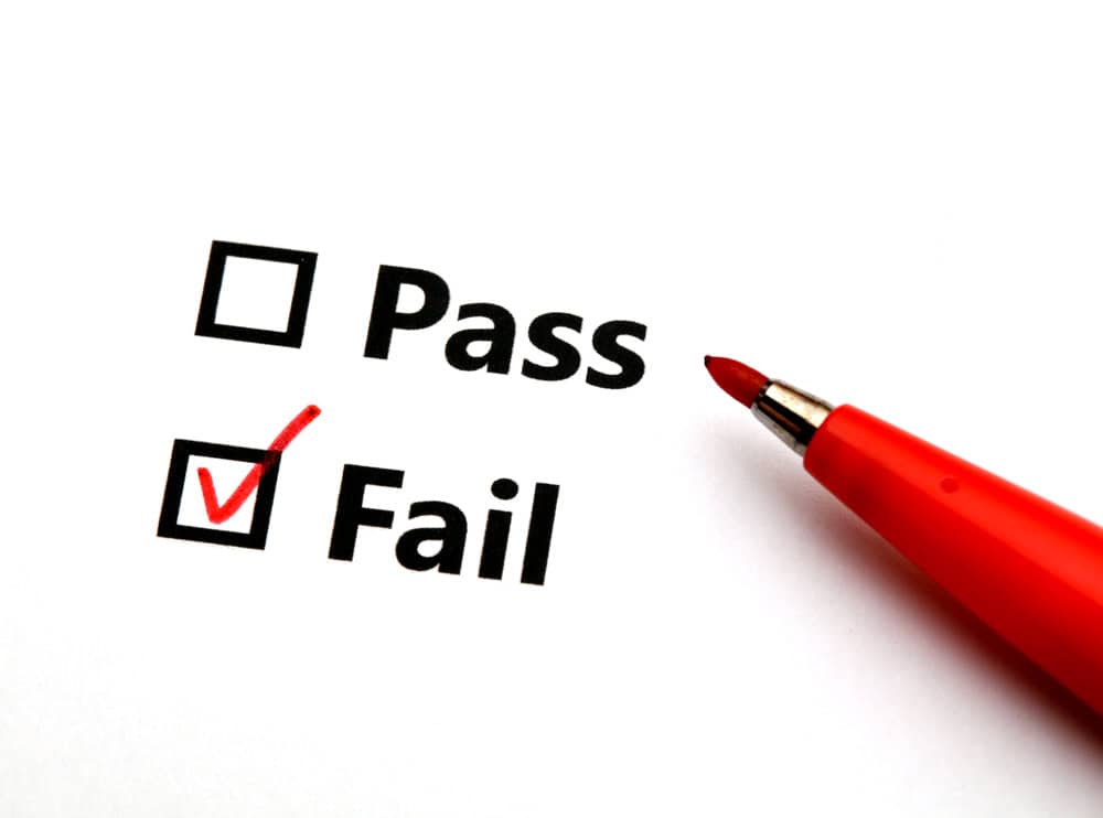 A red marker checks the "Fail" box on a test form, leaving "Pass" unchecked.