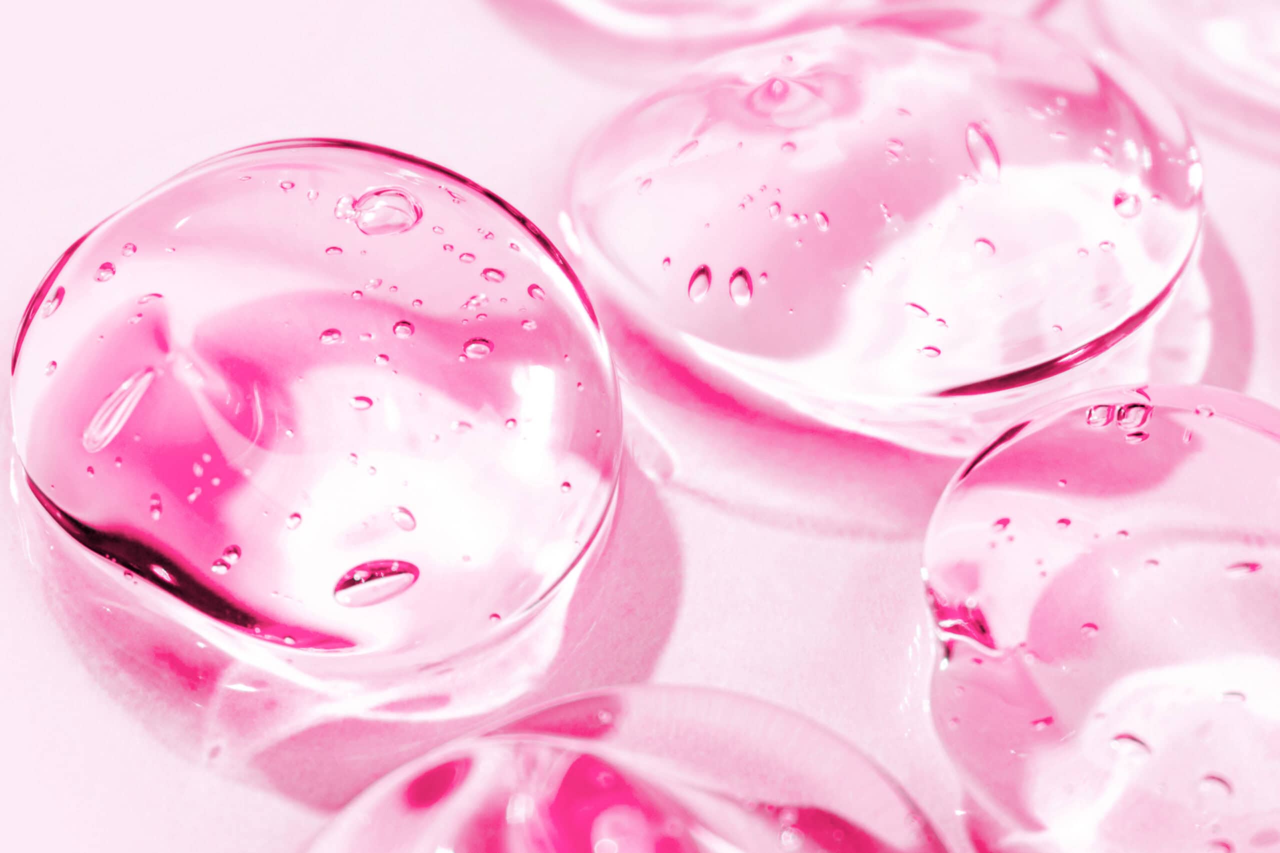 Transparent pink moisture face serum smeared. Hydrating hyaluronic acid. Hair gel with bubbles. Cosmetic products for makeup and skin care. Cosmetology.