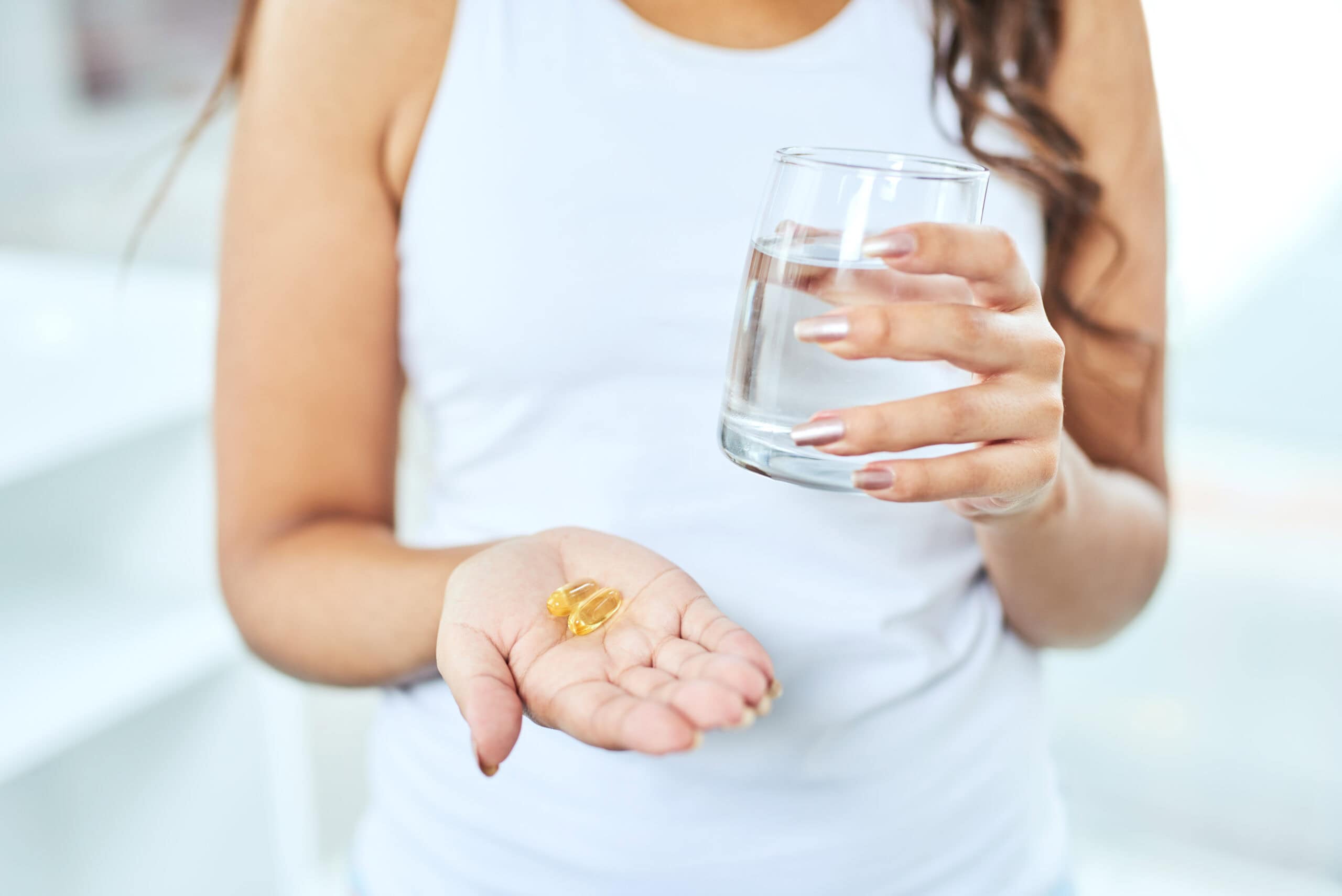Cropped shot of an unrecognizable woman drinking medication at home