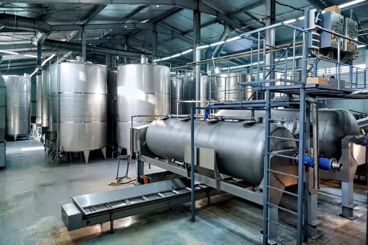 Stainless steel dairy processing tanks and equipment in a modern dairy facility.