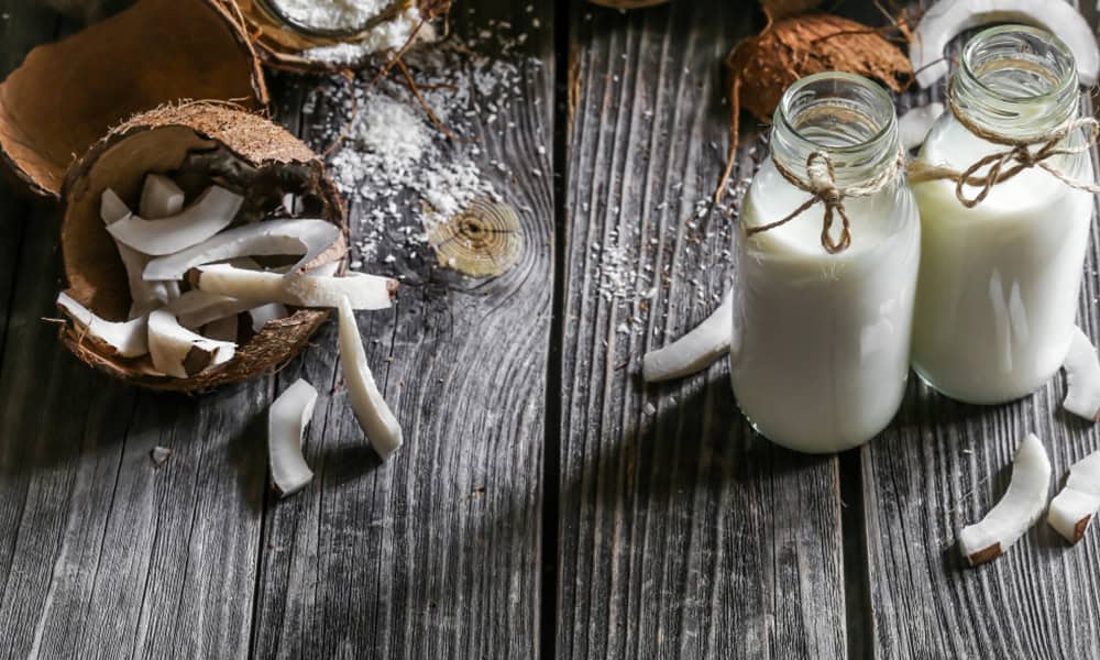 Fresh coconut and coconut milk in glass bottles for dairy products.