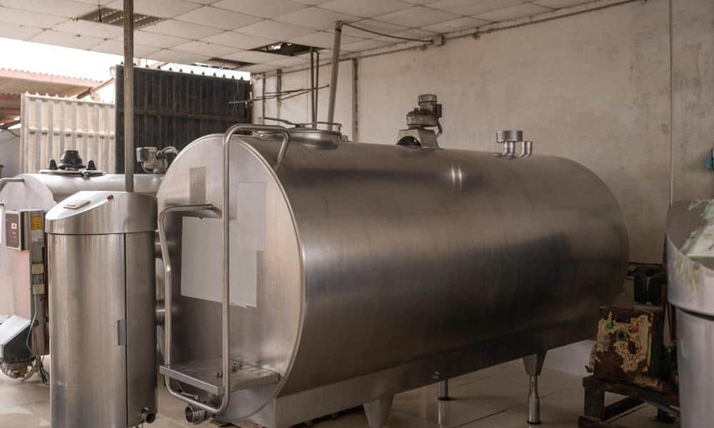 Stainless steel milk processing tank for dairy farm equipment and milk storage.