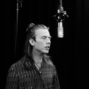 Erik Sjøholm recording with eyes closed in front of a NU-100K microphone