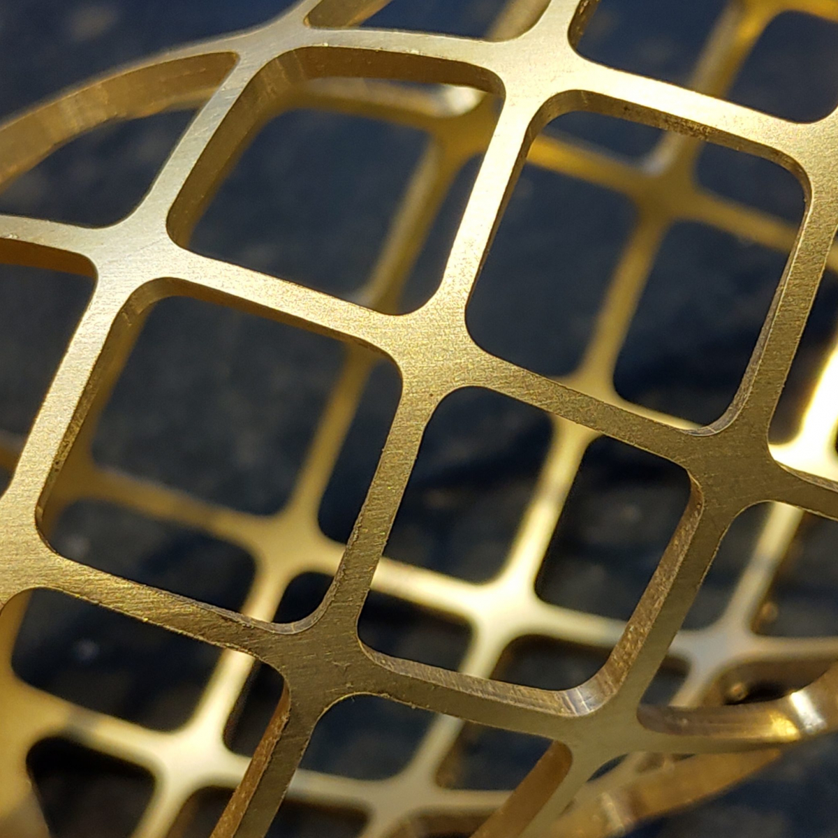 Detailed close-up of the golden lattice grille from a NU-100K microphone