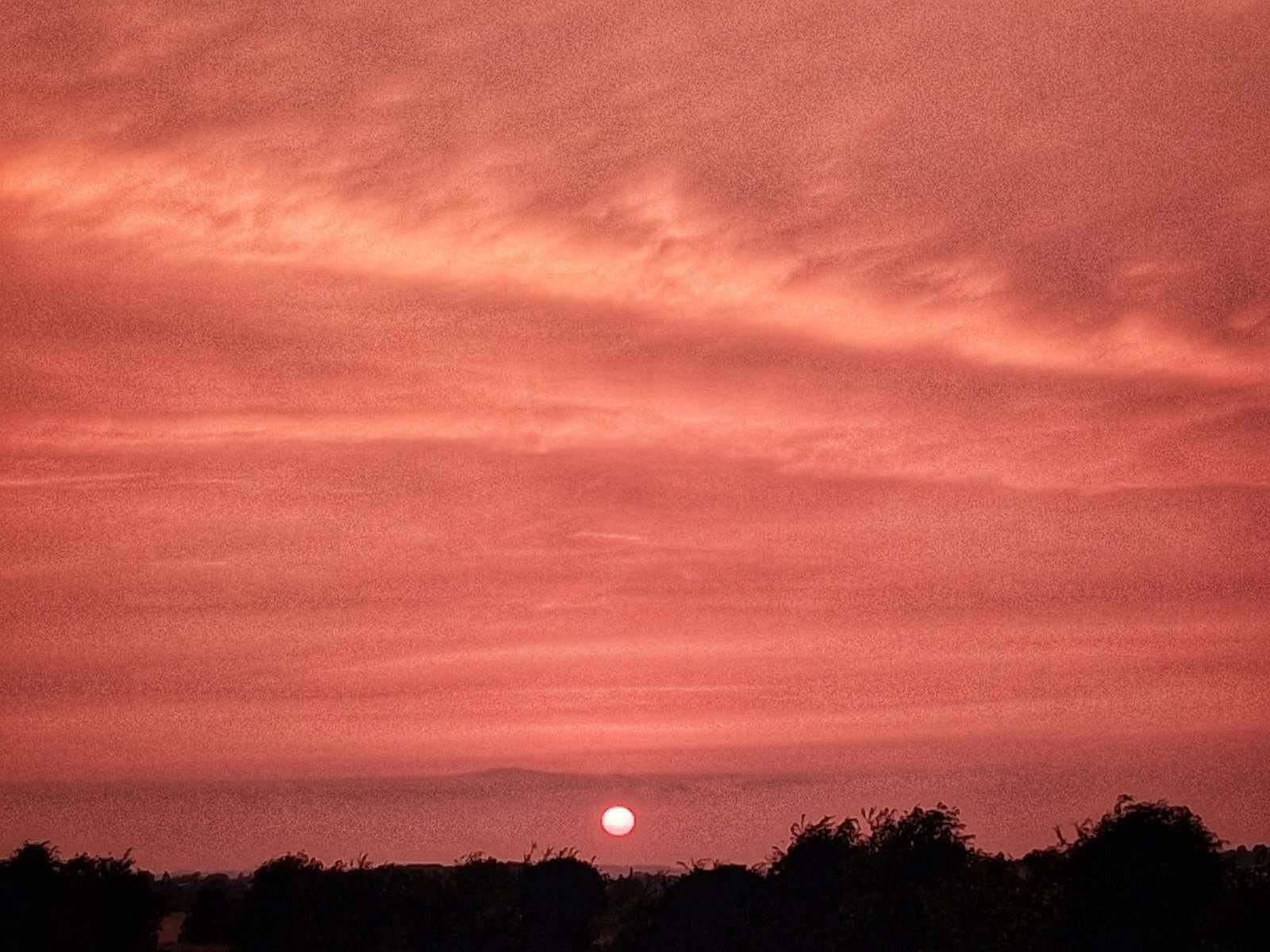 Vibrant sunset with colourful, cloudy sky.